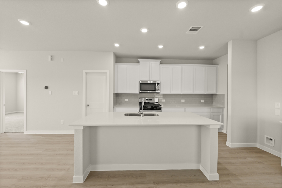 A kitchen with white cabinets.