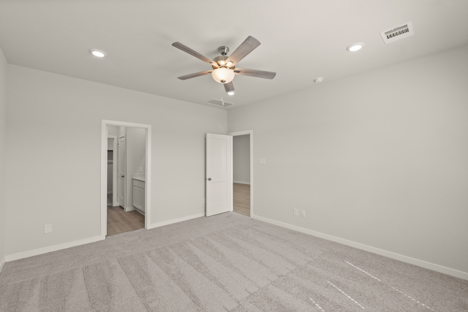 A room with a ceiling fan and a door.