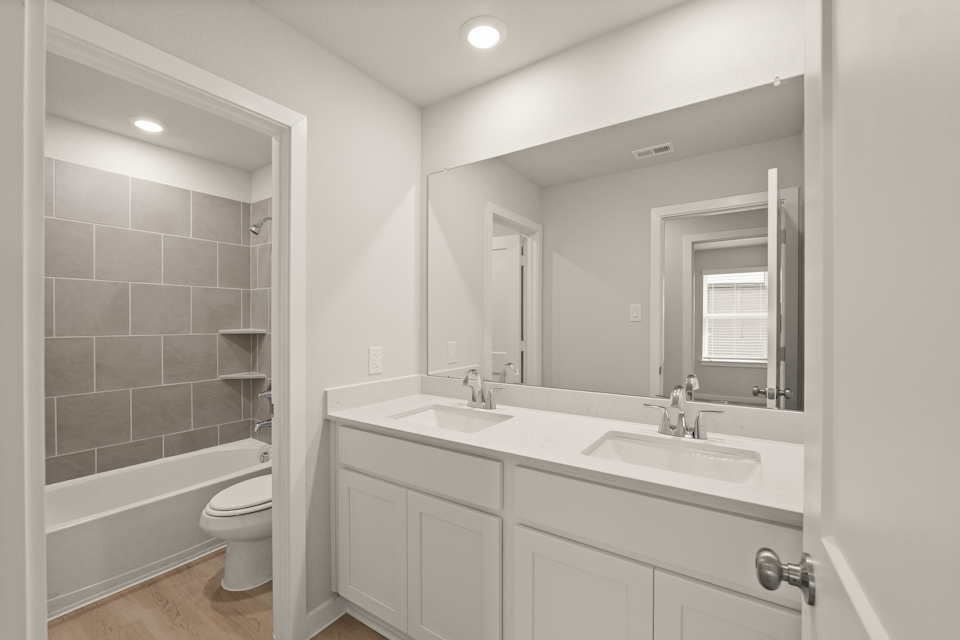 A bathroom with a large mirror.