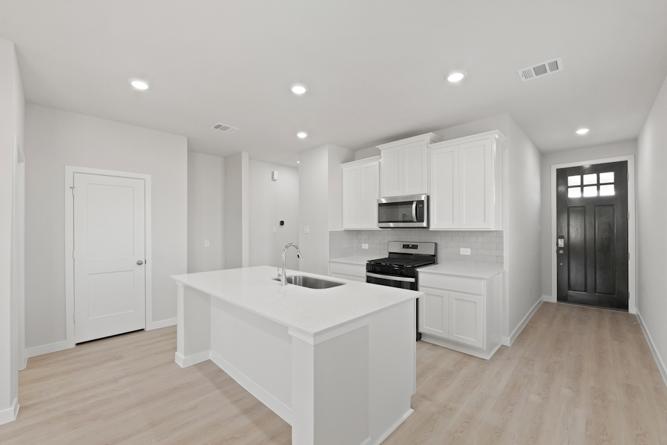 A kitchen with white cabinets.