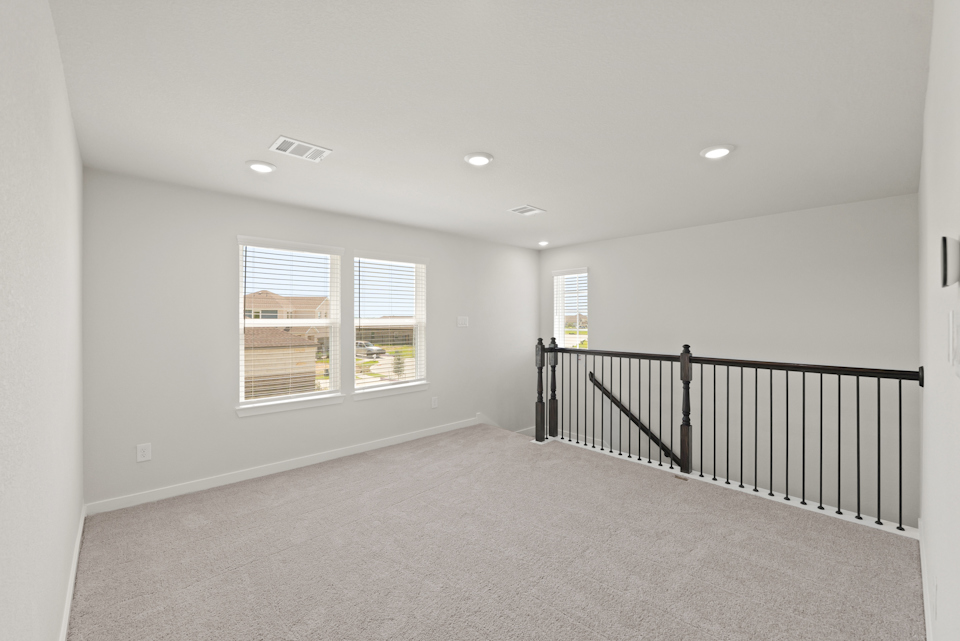 A room with a railing and windows.