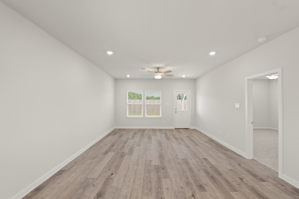 A room with a wood floor and a wood floor with a ceiling fan.