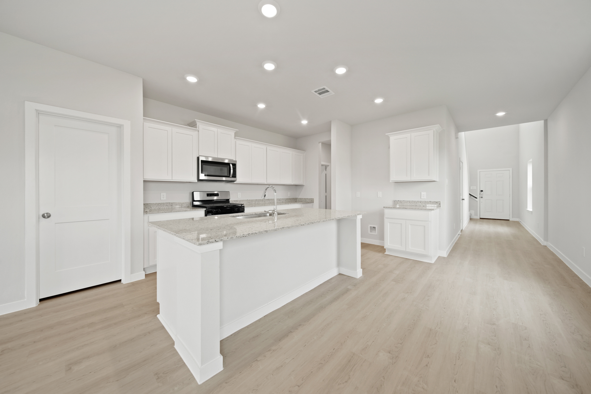 A kitchen with white cabinets.