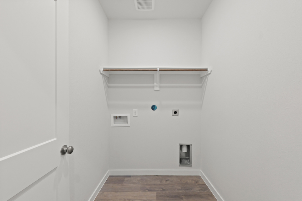 A white room with a wood floor and a white door.