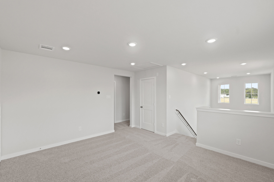 A room with white walls and a staircase.