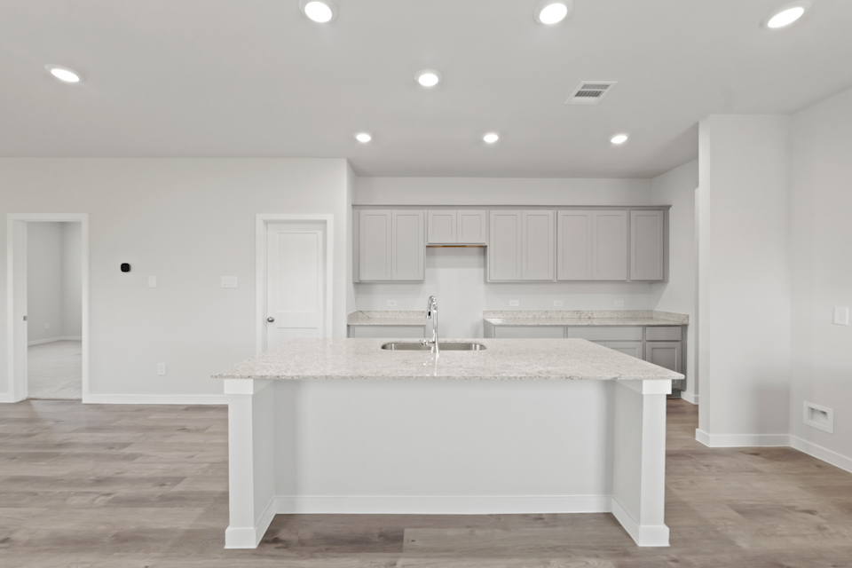 A kitchen with white cabinets.