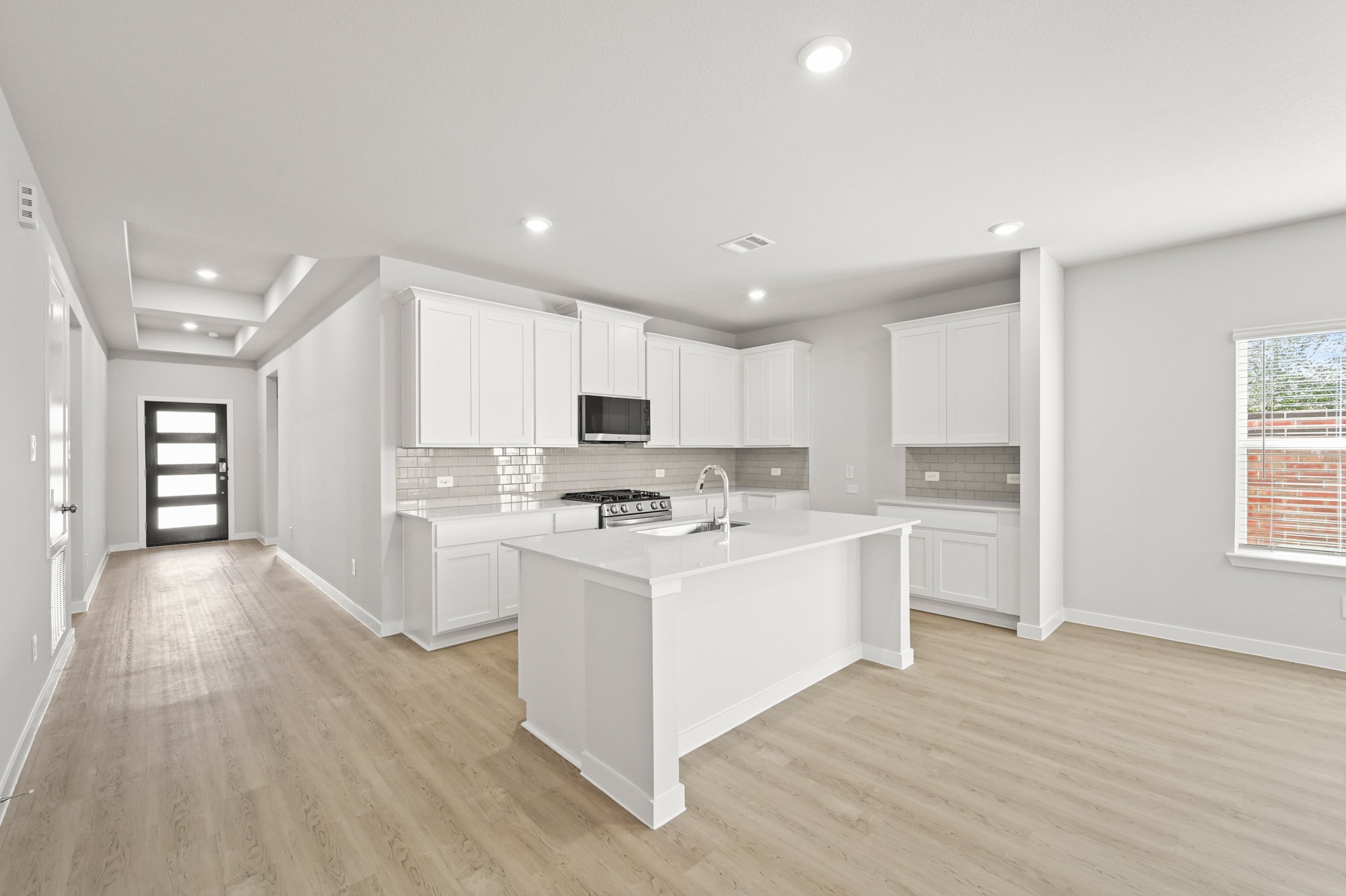 A kitchen with white cabinets.