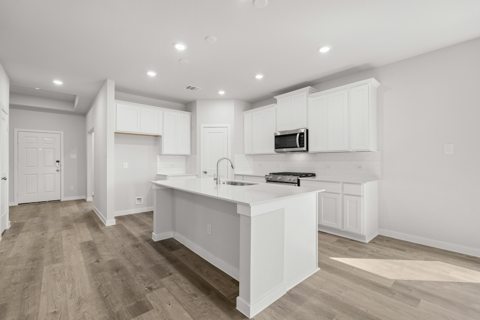 A kitchen with white cabinets.