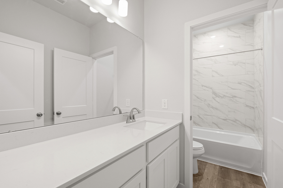 A bathroom with a tub toilet and sink.