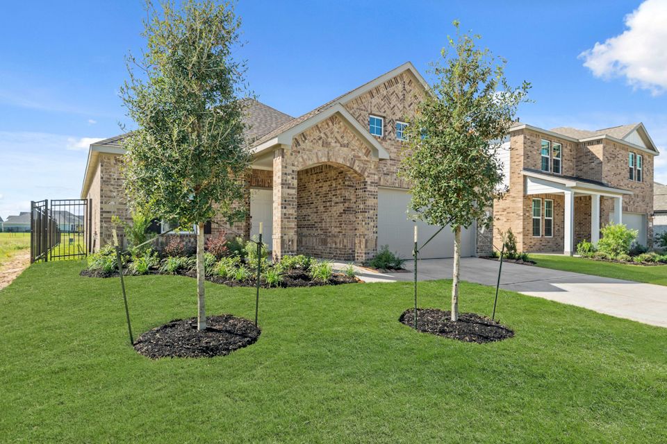 A large brick house with trees in front of it.