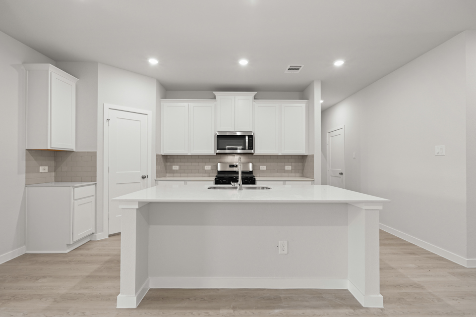 A kitchen with white cabinets.
