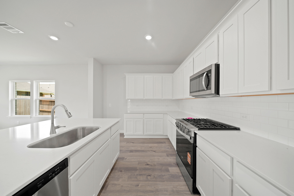A kitchen with white cabinets.