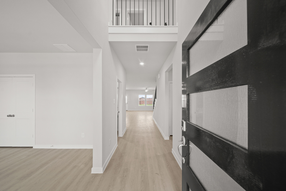 A hallway with white cabinets.