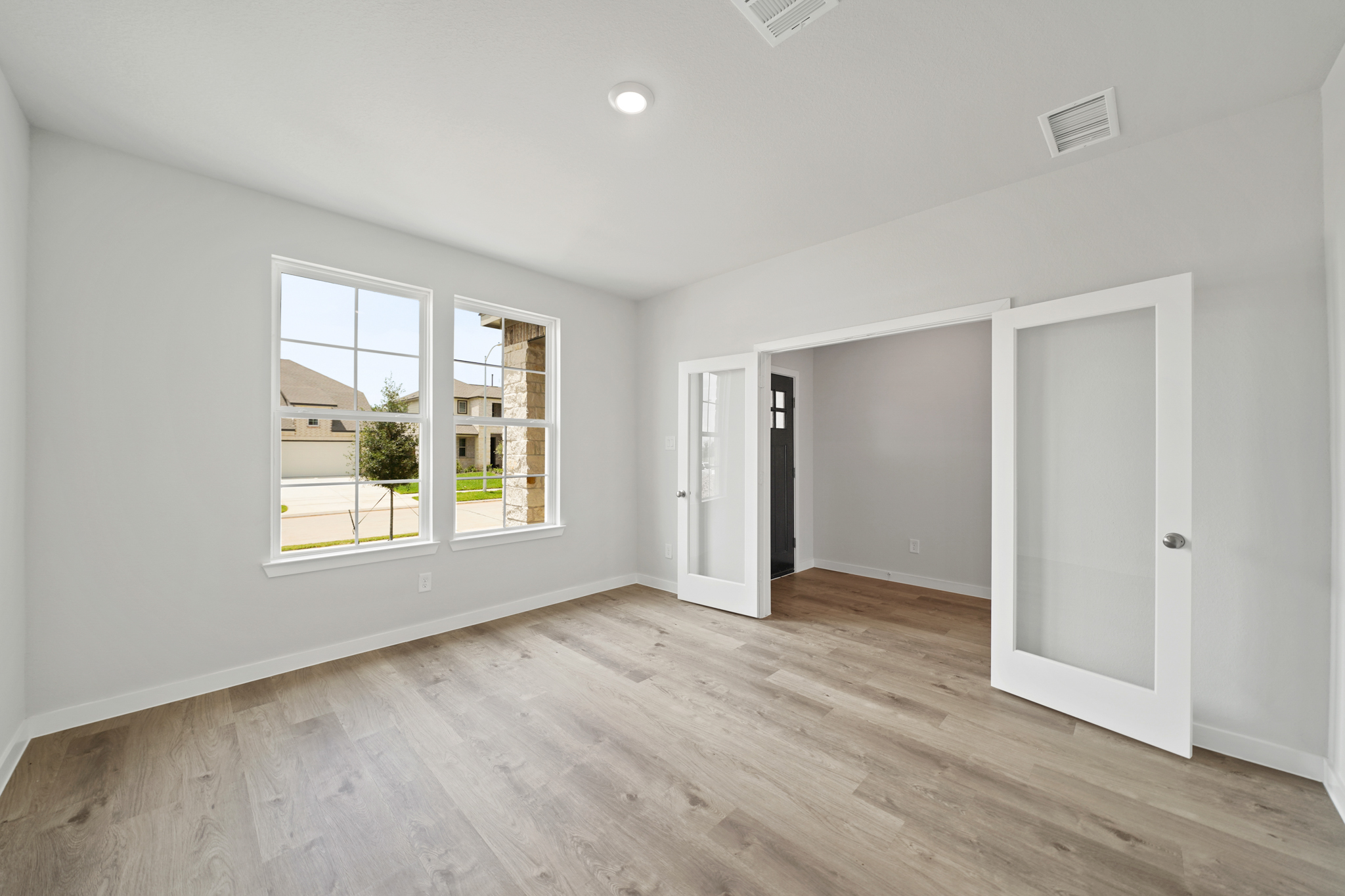 A room with a wood floor and a window.