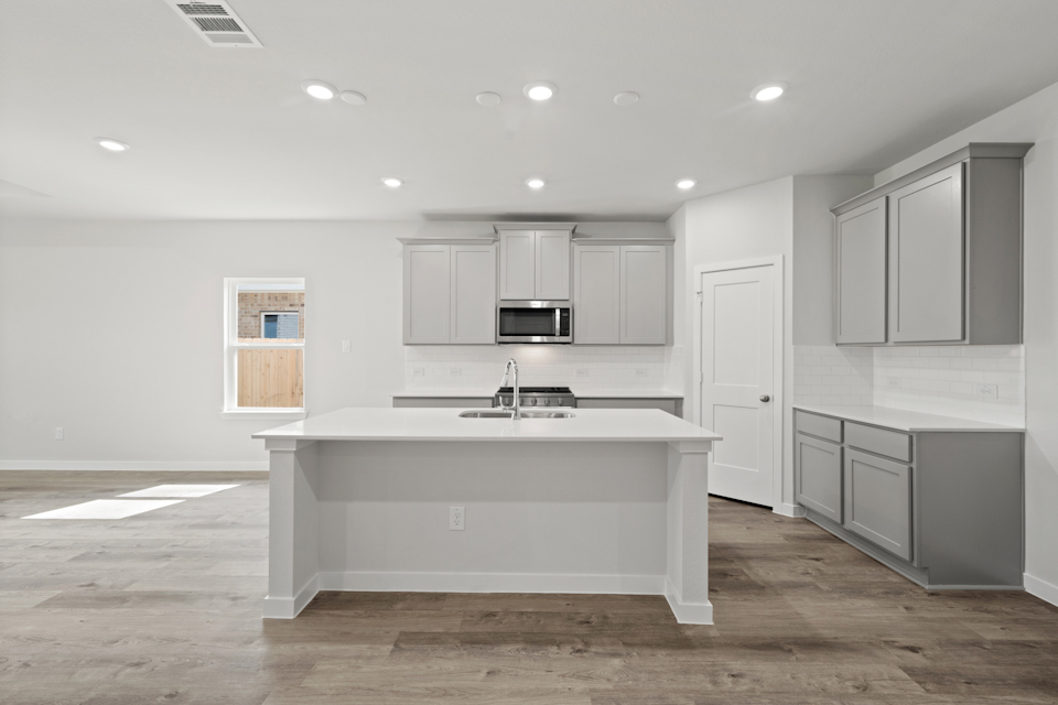 A kitchen with white cabinets.