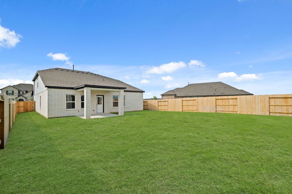 A grassy area with buildings in the background.