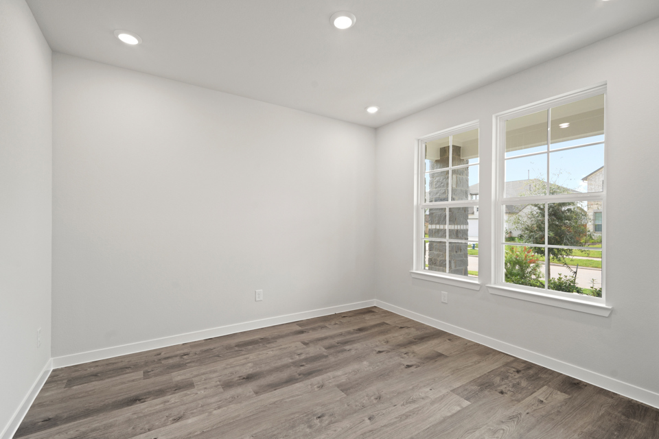 A room with windows and a wood floor.
