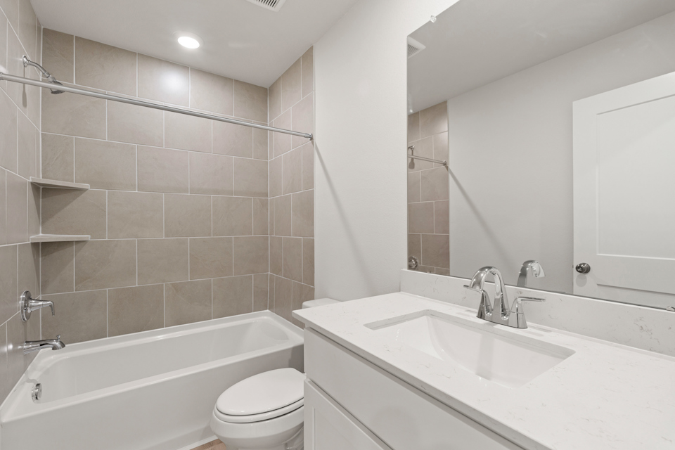 A bathroom with a tub sink and toilet.