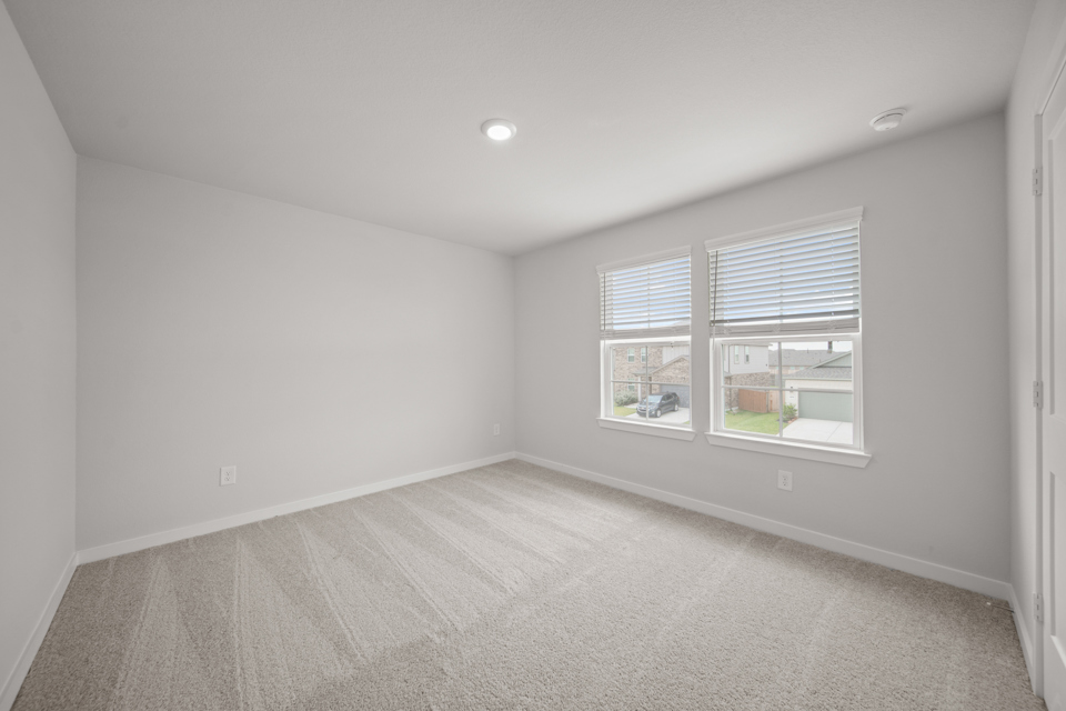 A room with a carpet and windows.