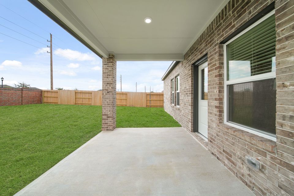 A brick building with a fence and grass.