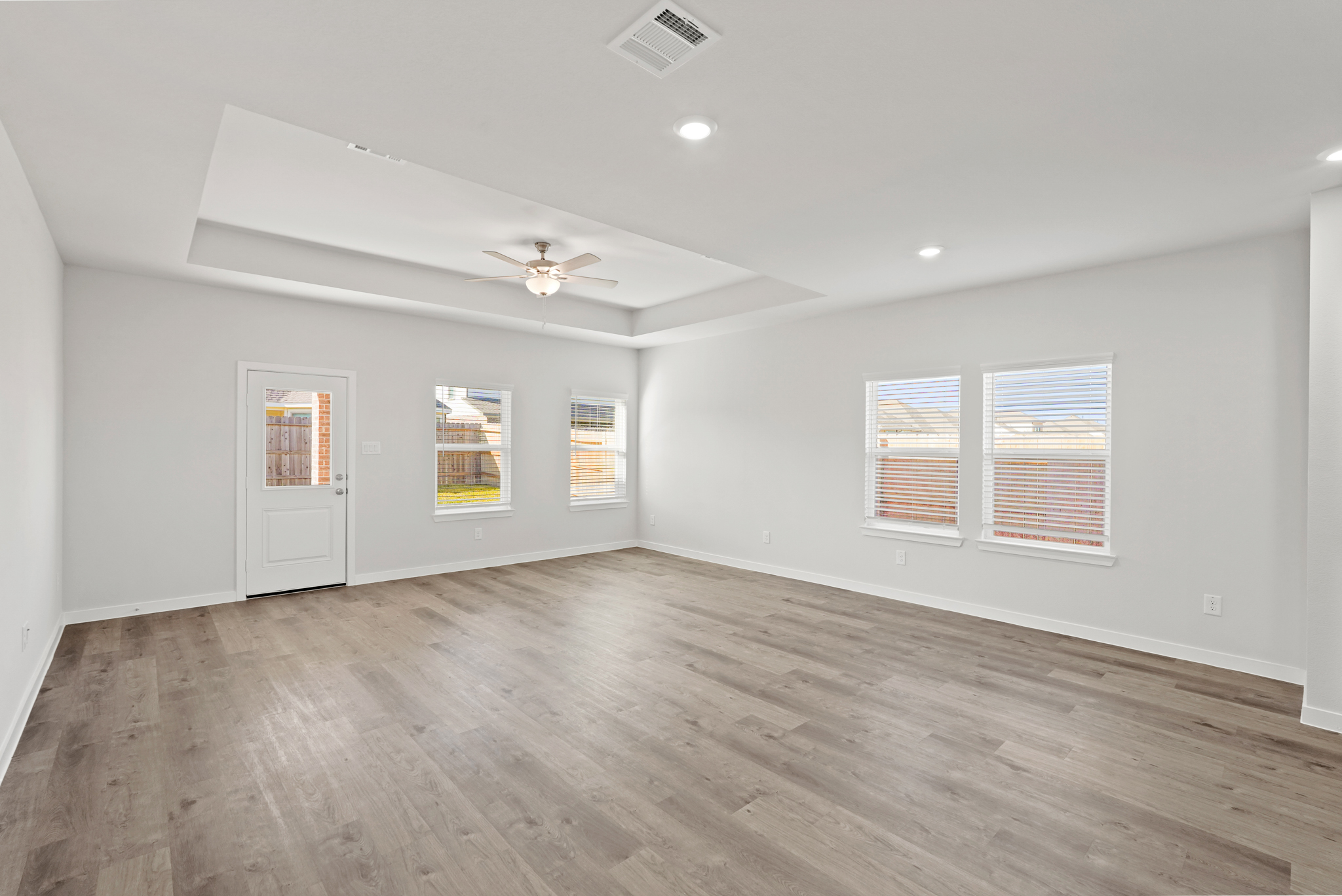 A room with a wood floor and a ceiling fan.