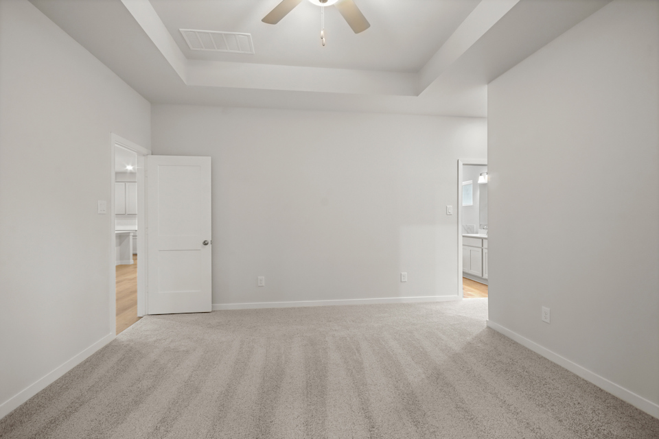 A room with white walls and a ceiling fan.