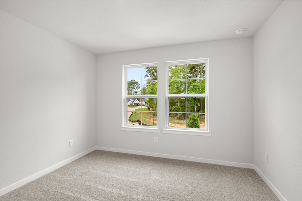 A room with a window and a carpet.