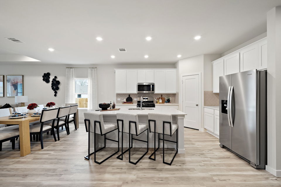 A kitchen with a dining table and chairs.
