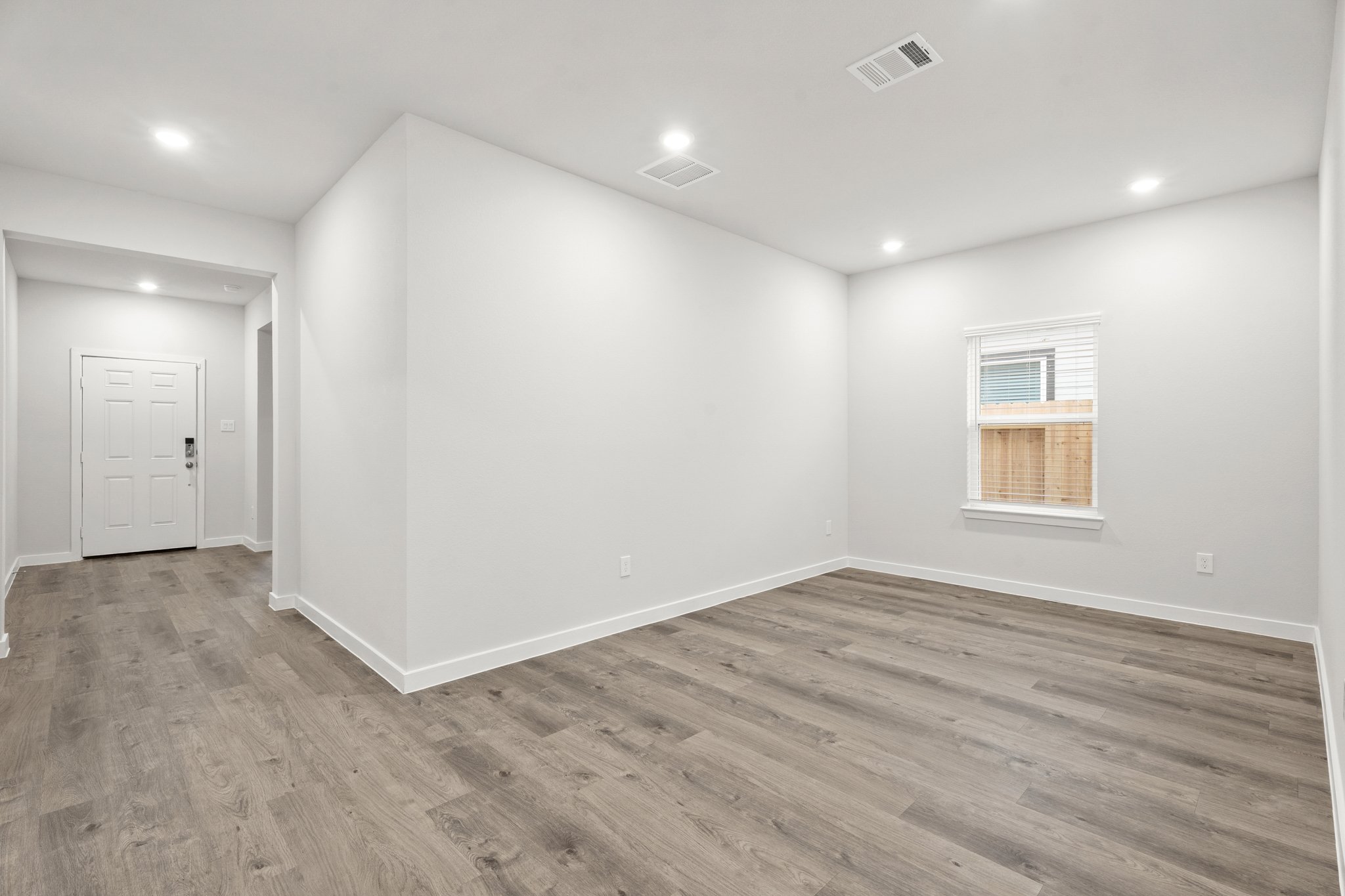 A room with a wood floor and a white door.