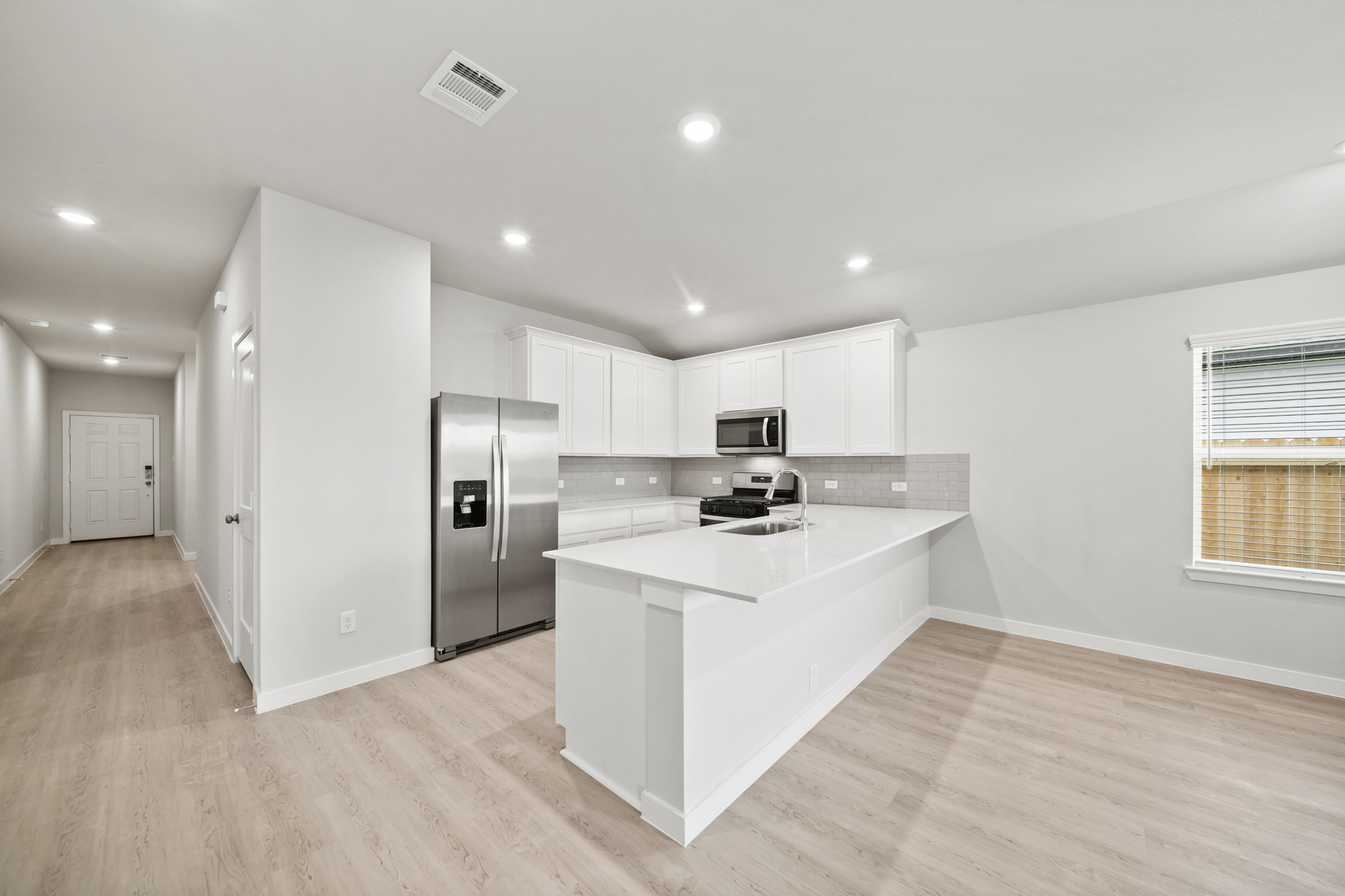 A kitchen with white cabinets.