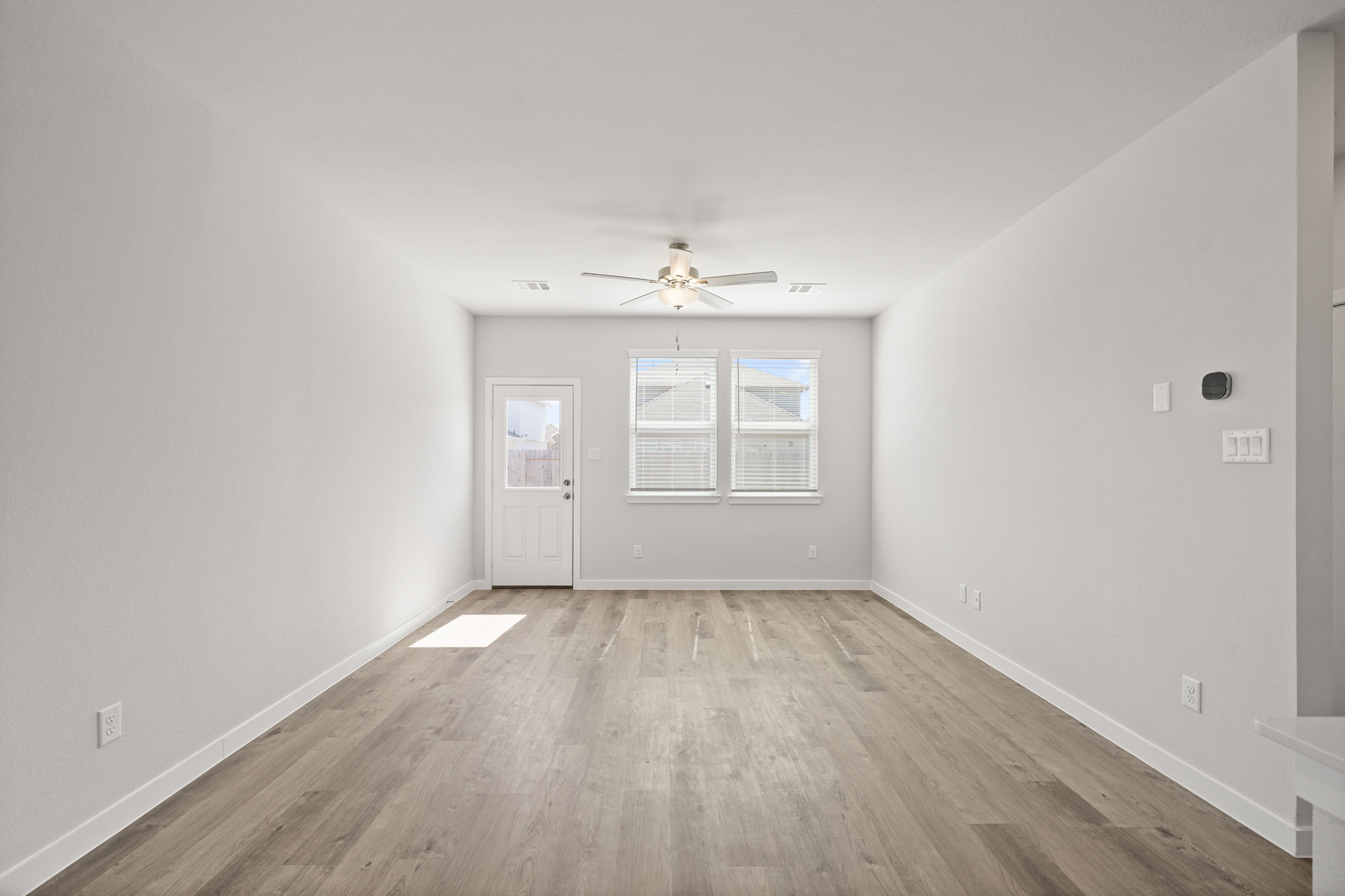 A room with a wood floor and a ceiling fan.