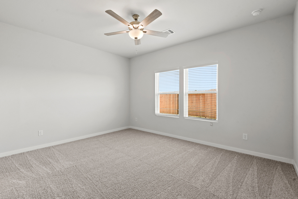 A room with a ceiling fan and a window.