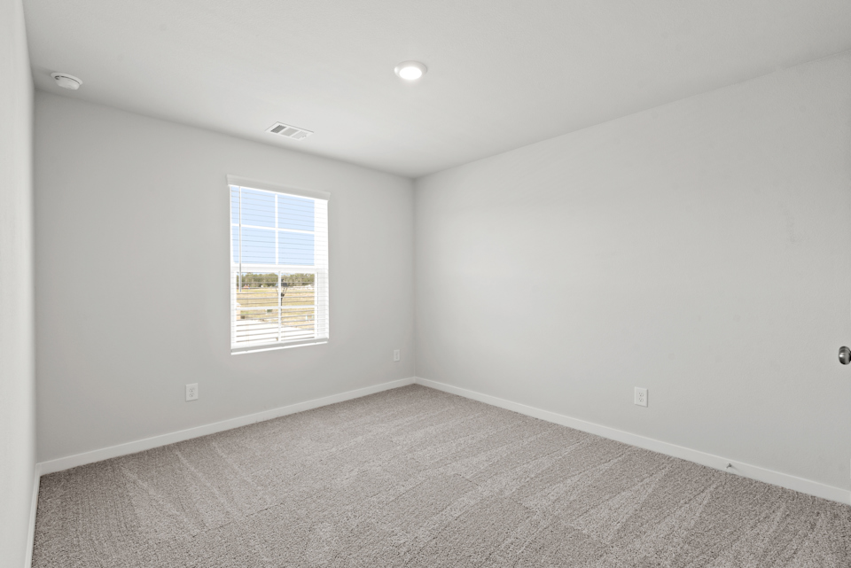 A room with a window and carpet.