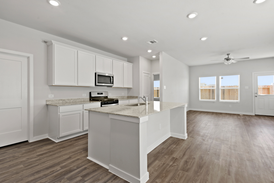 A kitchen with white cabinets.