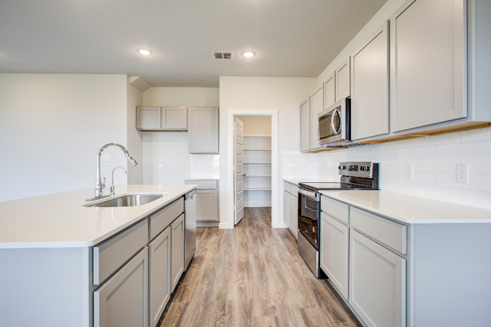 A kitchen with white cabinets.