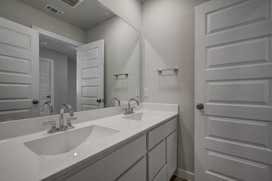 A bathroom with a large mirror.