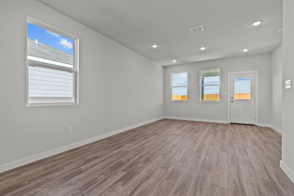 A room with a wood floor and white walls.