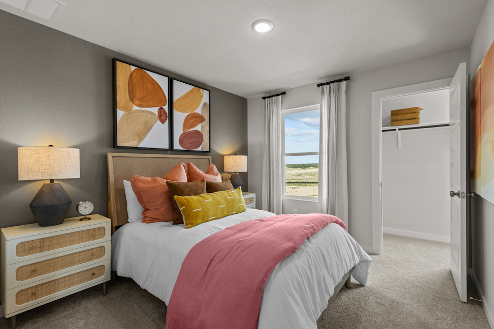 A bedroom with a bed and a lamp.