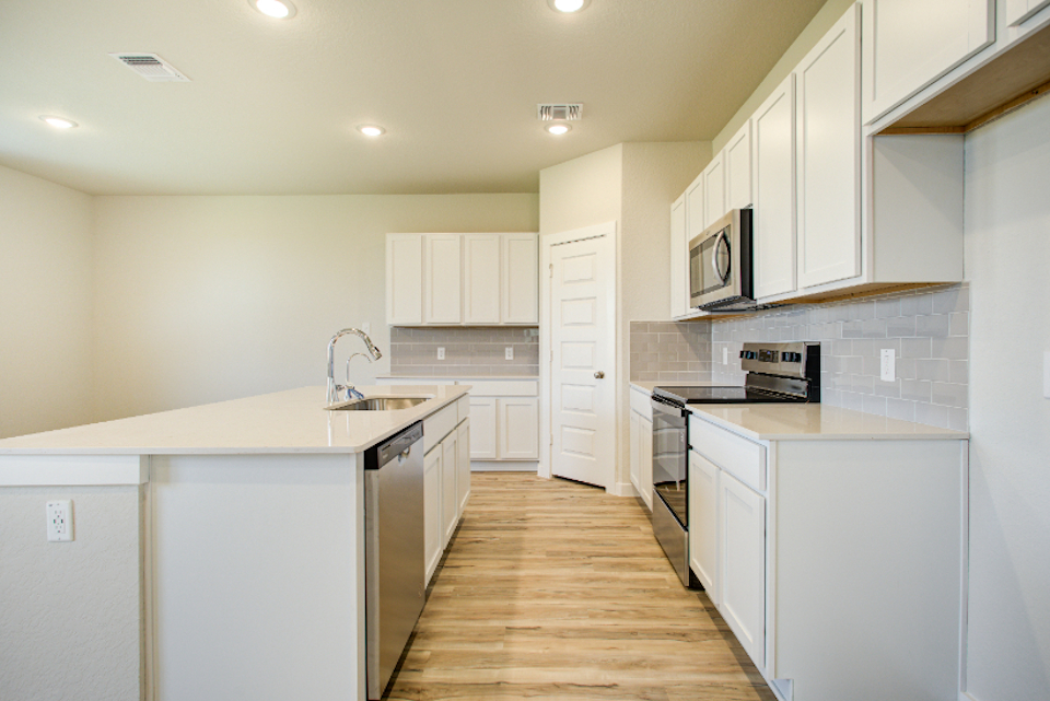 A kitchen with white cabinets.