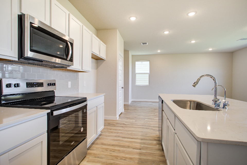 A kitchen with white cabinets.