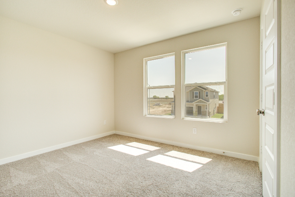 A room with a window and a rug in it.