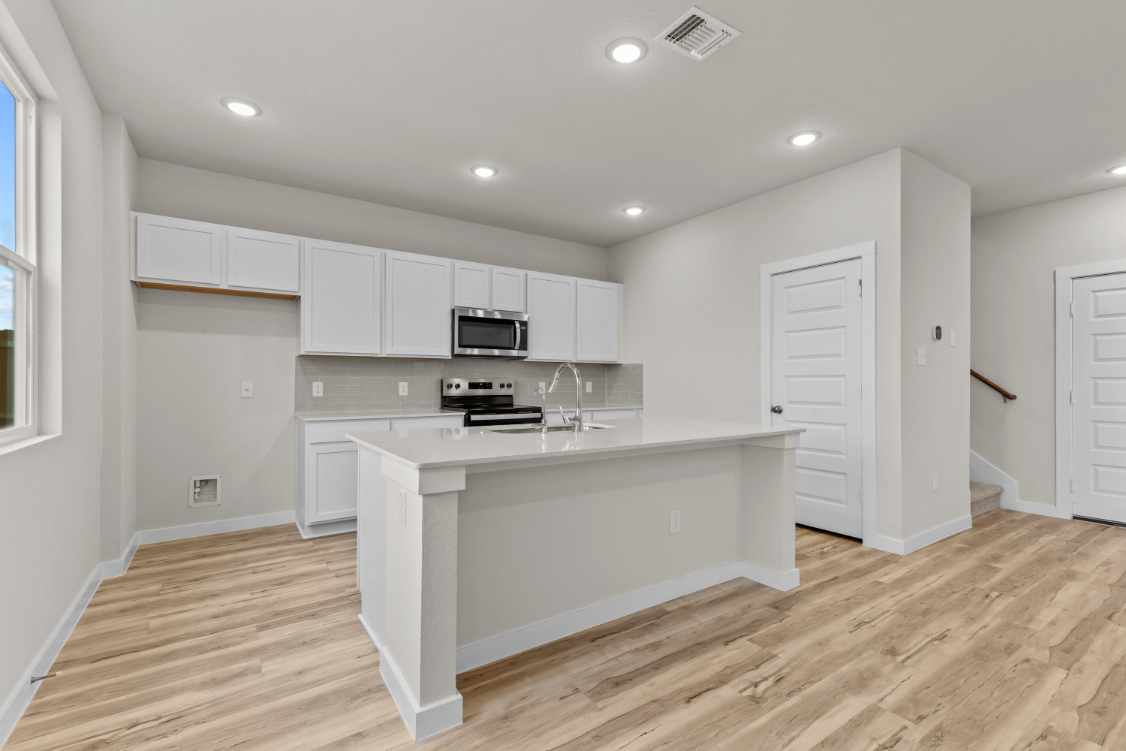 A kitchen with white cabinets.