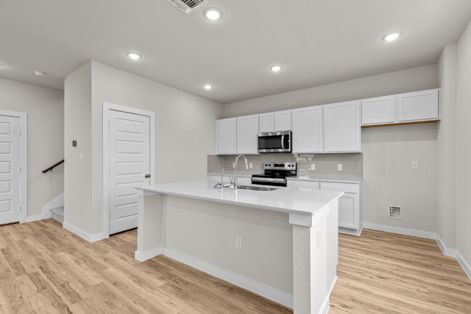 A kitchen with white cabinets.