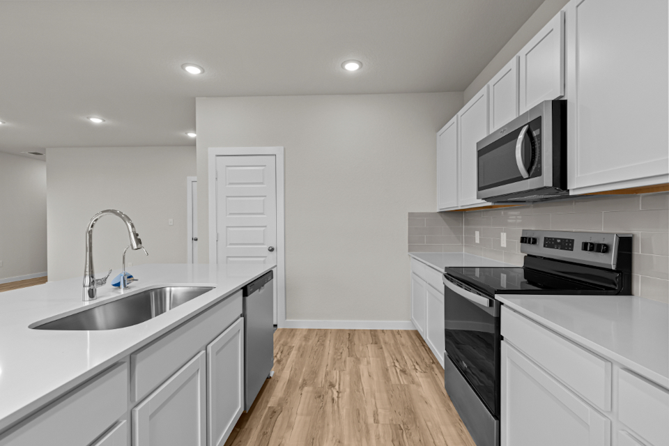 A kitchen with white cabinets.