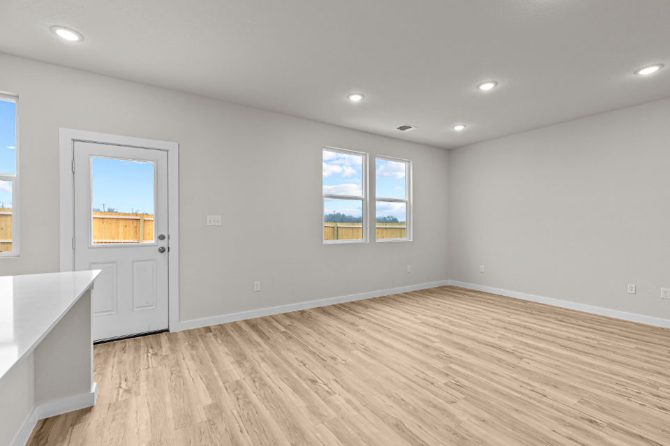 A room with a wood floor and a white door with a window.