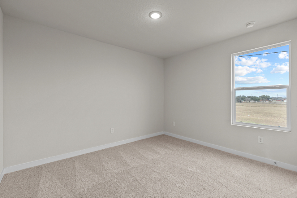 A room with a window and a painting on the wall.