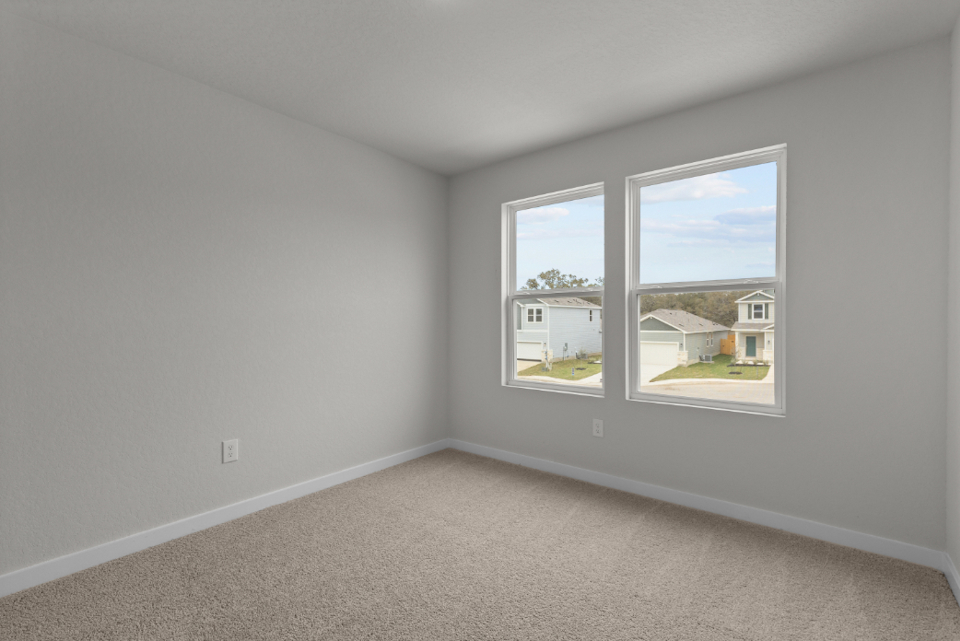 A room with a window and a carpet.