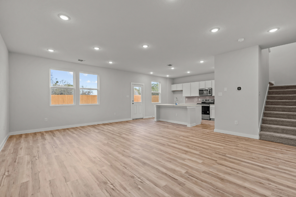 A large kitchen with a wood floor.