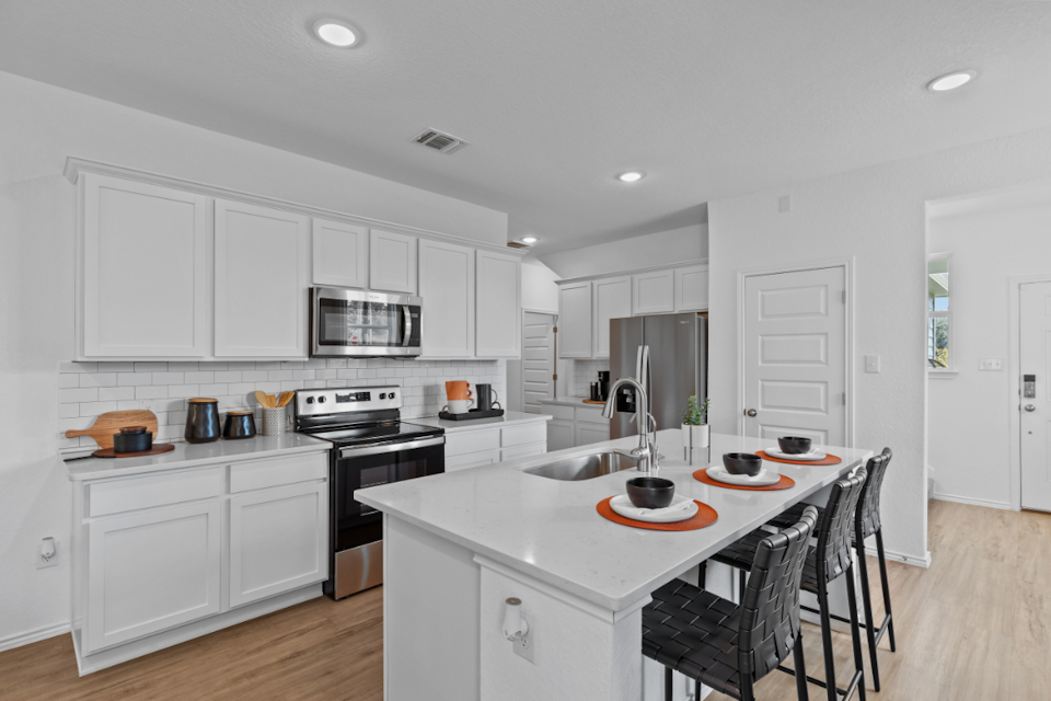 A kitchen with white cabinets.