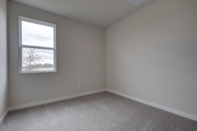 A room with a window and carpet.